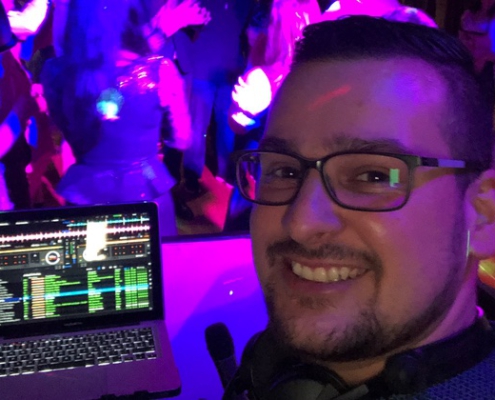 Selfie von DJ Zalmii vor seinem Laptop und den tanzenden Gästen