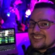 Selfie von DJ Zalmii vor seinem Laptop und den tanzenden Gästen
